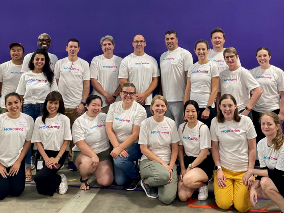 Group of people standing in front of purple wall