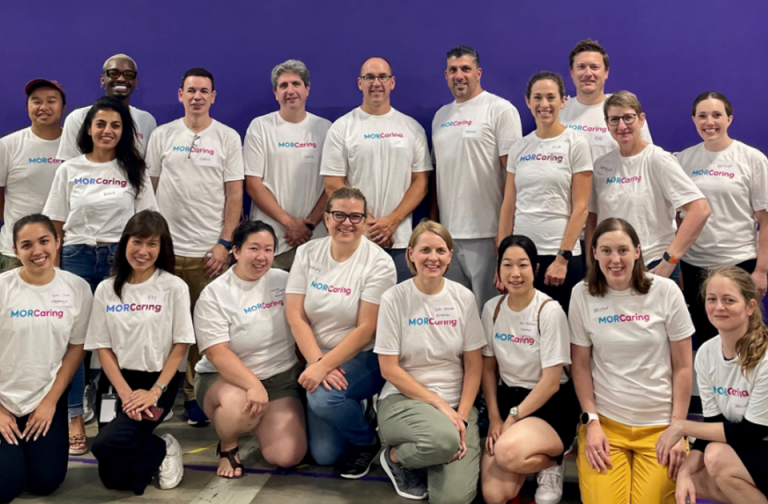 Group of people standing in front of purple wall