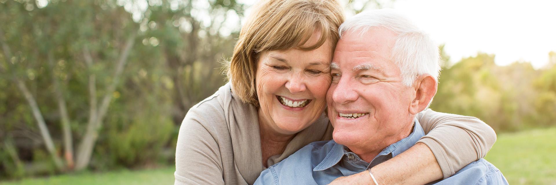 Woman smiling hugging a smiling man